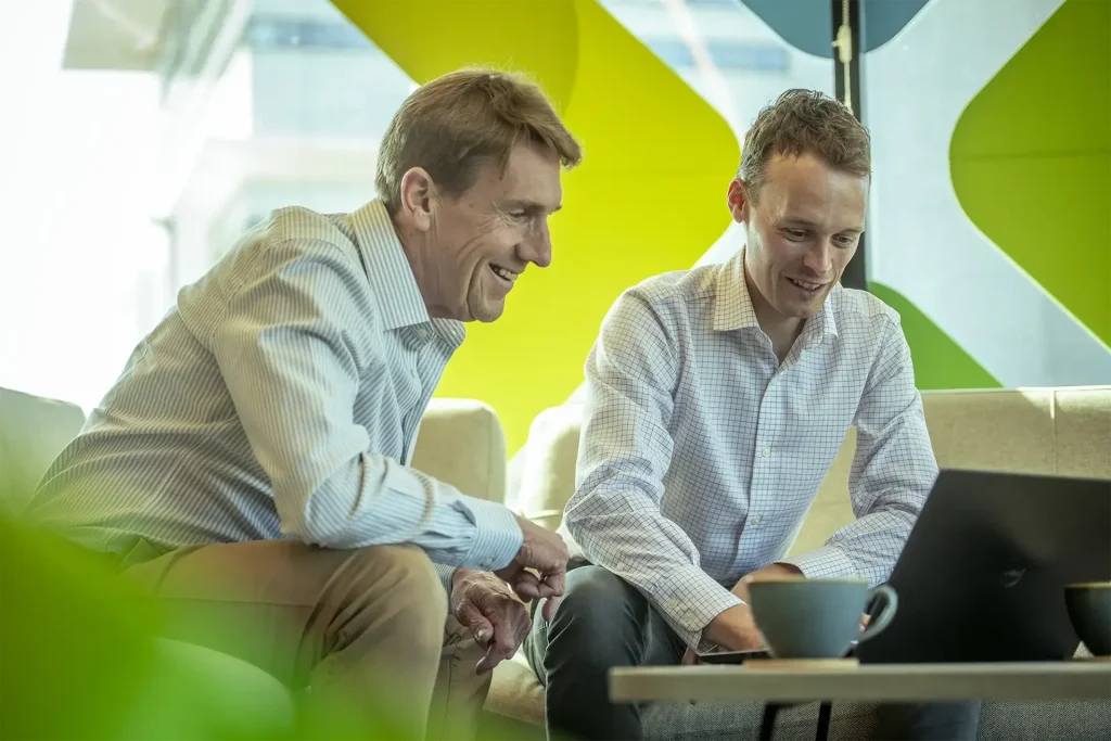 Two men looking at a laptop